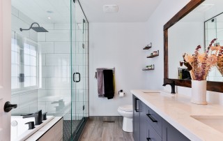 A beautifully remodeled bathroom with a big shower, modern fixtures, and dark cabinets